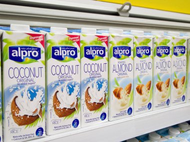Shelf in the supermarket with non-dairy milk. Coconut and almond vegetable drinks Alpro. Kyiv, Ukraine - September 2019