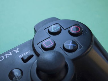 Sony Playstation 'ın siyah kumandasının parlak mavi arka planındaki kısmının odaklanmasını engelle. Kyiv, Ukrayna - Ağustos 2019