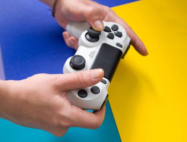 Sony Playstation için Sony Dual Shock marka beyaz bir joystick tutan kadın ellerinin üst görüntüsü. Kyiv, Ukrayna - Ağustos 2019