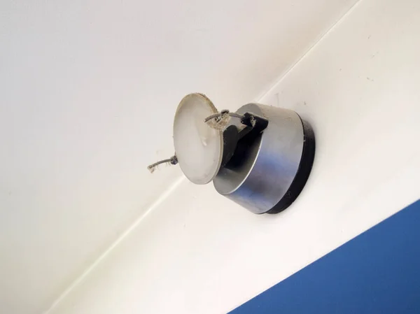 Örümcek ağı ve tozla kaplı bir duvar lambası. Tavanın altındaki duvarda alışılmadık bir ışık var. Oda uzun zamandır temizlenmemiş..