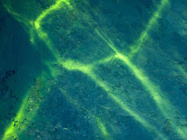 Turkuaz soyut arka plan ve sarı ışık çizgileri. Güneşli bir yaz gününde deniz yatağı ve deniz teması ile ilişkilendirilir..