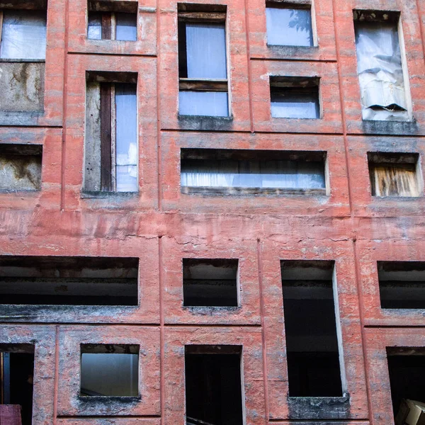 Hiç penceresi olmayan çok sayıda penceresi olan kırmızı duvar. Kare biçimi.