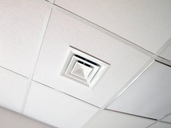 Hood on a false ceiling in an office room. Part of a split system that provides ventilation, air conditioning and heating.