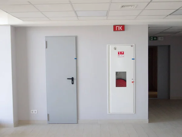 Yangın çıkışı, yangın hortumlu metal bir dolabın yanında..