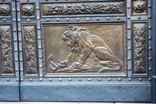 Eski metal bir kapının parçası. Burada yılanla dövüşen bir aslan tasvir ediliyor. Prag, Çek Cumhuriyeti - Ağustos 2018