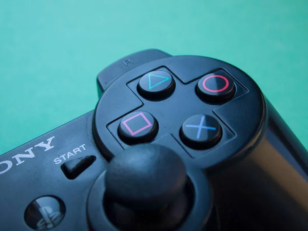 Sony Playstation 'ın siyah kumandasının parlak mavi arka planındaki kısmının odaklanmasını engelle. Kyiv, Ukrayna - Ağustos 2019