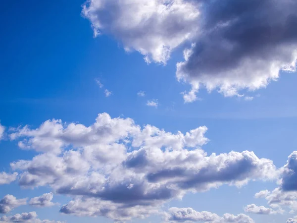 Bright blue sky with white and gray clouds. Beautiful dramatic stormy sky on a rainy day.