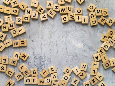 Gri arkaplandaki ahşap harflerden yapılmış bir çerçevenin üst görüntüsü. Boşluğu kopyala.