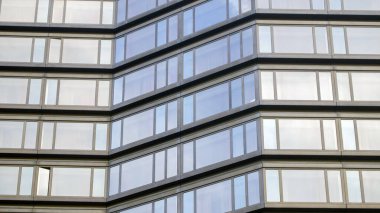Geniş pencereli, modern gri bir binanın parçası. Bir pencere açık..