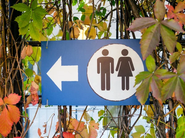 Parkta ok işaretli eski umumi tuvalet tabelası..