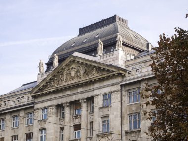 Ağaçların turuncu ve kahverengi yaprakları arasındaki güzel gri binanın manzarası..