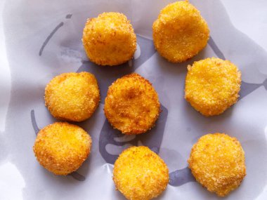 Beyaz kağıt üzerinde peynirli kroket manzarası. Lezzetli aperatif.