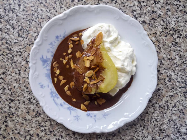 Krem şanti, çikolata sosu ve badem gevreğiyle kaynatılmış karamelli armut. Fransız poire belle Helene.