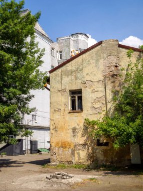 Terk edilmiş bir evin ve bahçenin yan görüntüsü.