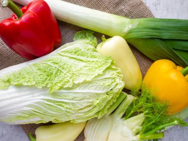 En iyi çiğ sebze manzarası. Kırmızı ve sarı dolma biber, Çin lahanası, pırasa ve rezene.