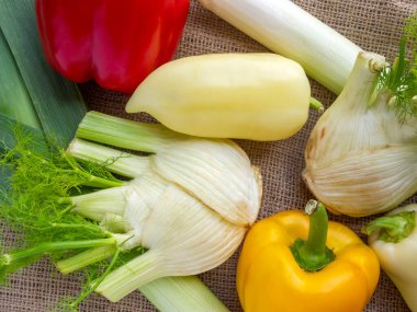 Taze çiğ sebze manzarası. Kırmızı, turuncu ve beyaz dolma biber, rezene, pırasa