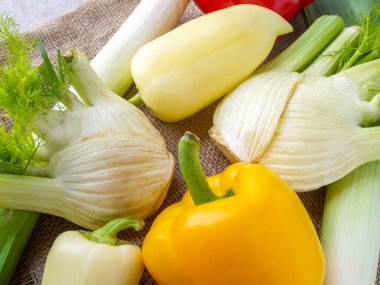 Taze çiğ sebzelerin yan görüntüsü. Sulu portakal ve beyaz dolma biber, rezene, pırasa