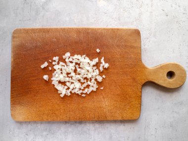 Tahta doğrama tahtası ve soğan dilimlerinin üst görüntüsü.