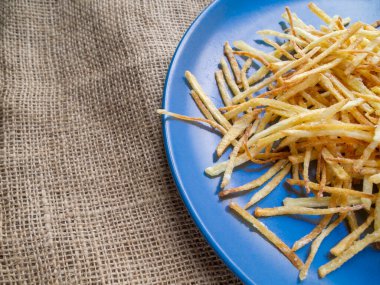 Kaba bir kumaş üzerinde bir tabak lezzetli kızarmış patates..