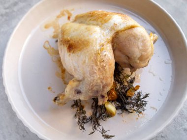 Kırsal bir zeminde baharatlı ve sarımsaklı fırında tavuğun yan görünüşü.