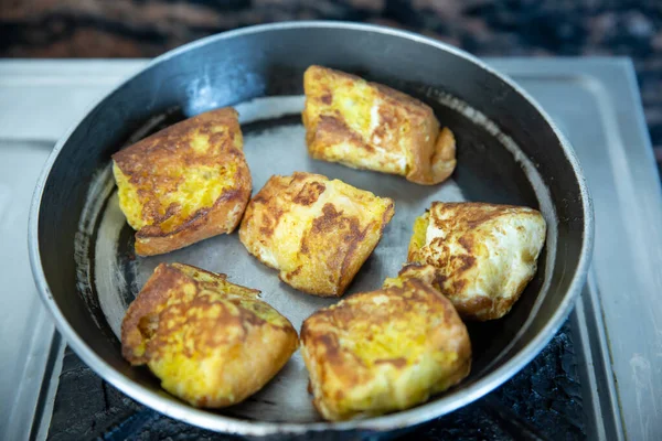 Burger bread cut into pieces and dip into Egg yolk mixed with salt and fried with ghee on a frying pan. Fried Burger Bread,Breakfast snacks