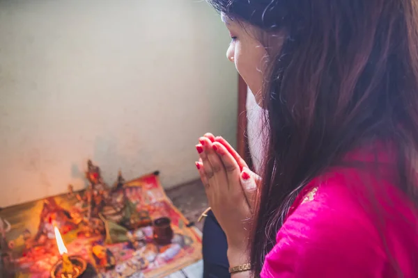 ヒンズー教の女性は家で神に祈りを捧げる ヒンズー教の信者は ナマステをすることによって神に祈ります デパワリ祭の間に神を崇拝するネパールの女の子 選択的焦点 ロイヤリティフリーのストック写真