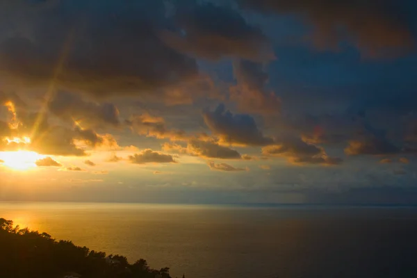 Renkli deniz ve bulutlar gün batımında.