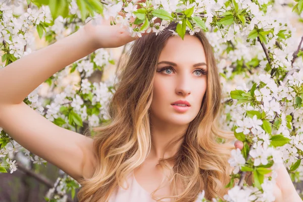 Fille aux cheveux longs sur le fond de l'arbre blanc en fleurs — Photo