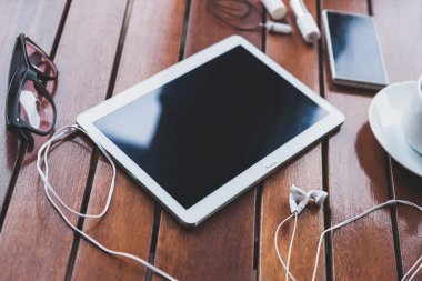 Beyaz mobil cihazlar üzerinde kahverengi ahşap bir masa yalan