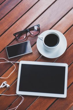 Beyaz mobil cihazlar üzerinde kahverengi ahşap bir masa yalan