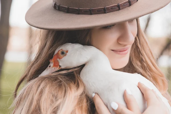 Portrait d'une fille qui tient le canard blanc. Bird regarde directement la caméra. Canard posé sa tête sur l'épaule de la fille . — Photo