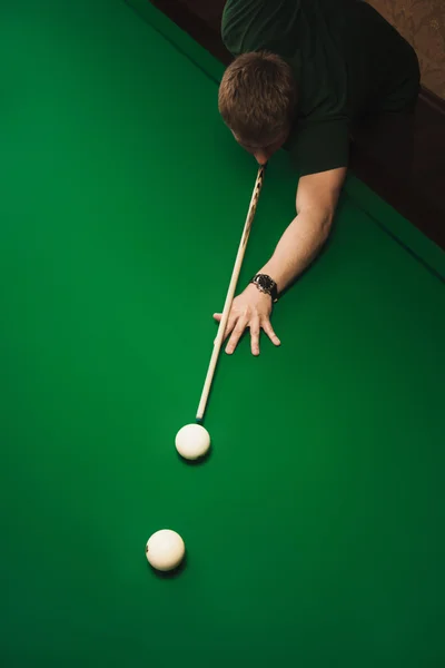 The guy plays billiards and aim the ball in the hole. Focus on center of photo. View from above. Empty space for text. — Stock Photo, Image