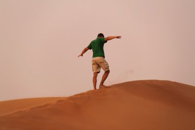 Adam çölde kum tepesinin kenarında