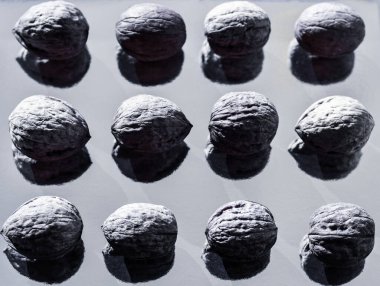 cevizler güzel gölgeli ayna yansıtıcı yüzeyde çizgilerle kaplıdır. Dağınık cevizlerin siyah beyaz fotoğrafı