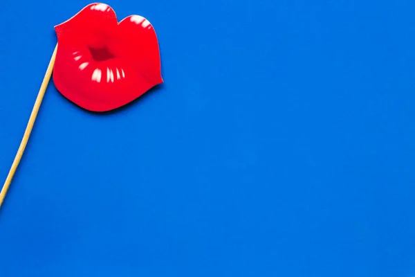 red kiss on a stick for Valentine\'s day on a blue background