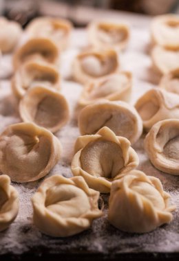 Tahtaya un serpiştirilmiş el yapımı et serpiştirilmiş bir sürü hamur işi.