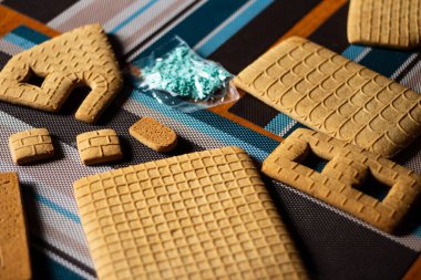 Mutfak masasında uzanmak için zencefilli kurabiye yapan bir evin parçaları.