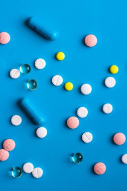 mavi arka planda çok renkli haplar ve kapsüller