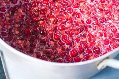 Vişne likörü hazırlarken bir tencerede kırmızı kirazlar. Koruma, kiraz reçeli, komposto