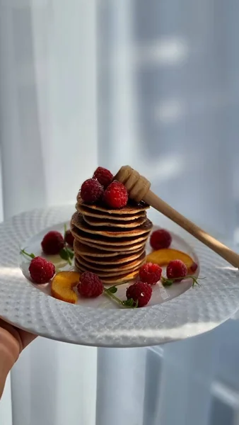 Pfannkuchen Mit Himbeeren Pfirsich Und Honig Auf Einem Weißen Teller — Stockfoto