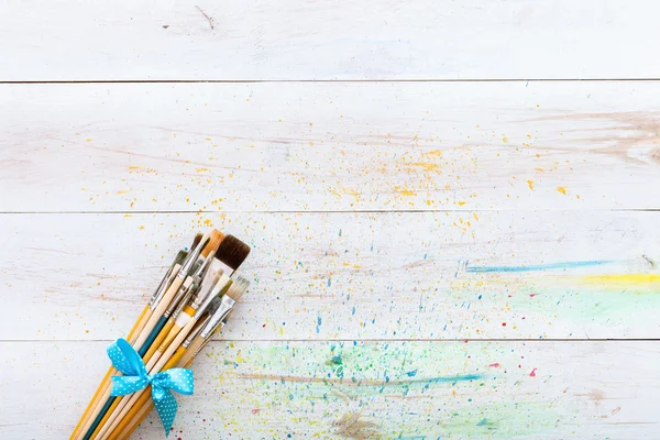 Artist brushes on white wooden planks — Stock Photo, Image