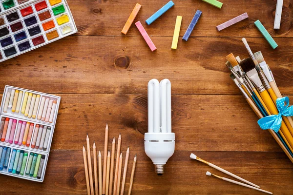 Artist brushes, paints, chalks and lamp — Stock Photo, Image