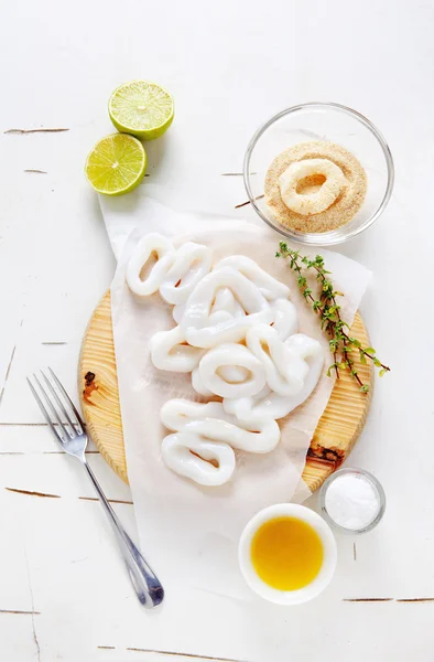 Aros de calamar crudos en rodajas con lima, aceite de oliva, migas de pan. Prepar —  Fotos de Stock