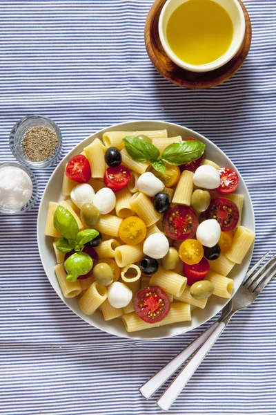 Nudelsalat auf blau gestreifter Tischdecke. italienischer Sommer leicht zu heilen — Stockfoto