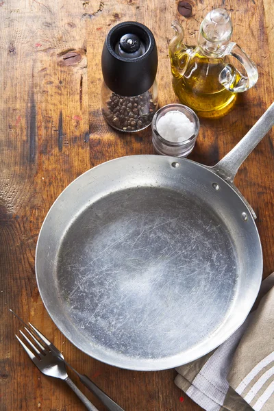 En tom kastrull på ett träbord. salt, peppar, olivolja olja. utrymme f — Stockfoto