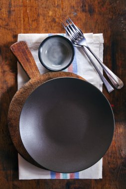 ahşap doku arka plan üzerine bir havlu üzerine boş siyah kase. girintili