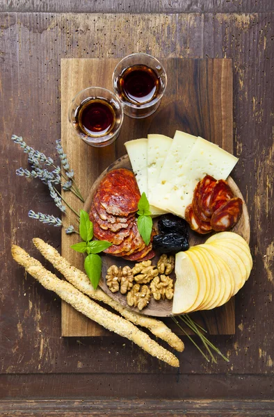 Snacks on a clay plate with wine Marsala . on wooden background. — Stock Photo, Image