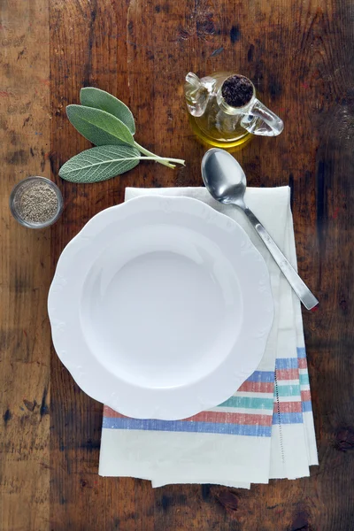 Пустая белая тарелка на полотенце на деревянном фоне текстуры. oli — стоковое фото