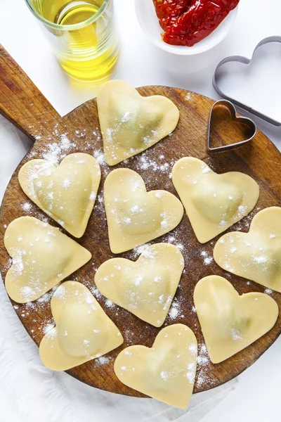 fresh Italian ravioli in shape of heart. food background. on whi