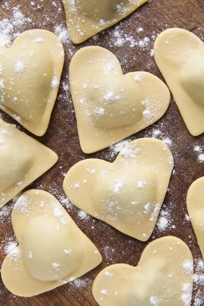 fresh Italian ravioli in shape of heart. food background.